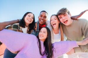 Teenagers smiling confidently with perfect teeth veneers, showing bright smiles and positive expressions